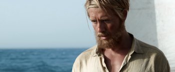 Movie still from “Kon-Tiki” (2012), directed by Espen Sandberg – A person with long hair and a beard; Close Up shot, Over the shoulder angle