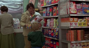 Movie still from “Kramer vs. Kramer” (1979), directed by Robert Benton – A woman and a child in a store looking at products on a shelf; Medium shot, Over the shoulder angle