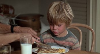 Movie still from “Kramer vs. Kramer” (1979), directed by Robert Benton – A child eating a meal at a table with a glass of milk; Close Up shot, High angle