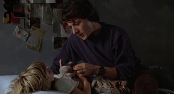 Movie still from “Kramer vs. Kramer” (1979), directed by Robert Benton – A man holding a stuffed animal while a little girl looks on; Medium shot, Over the shoulder angle