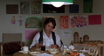 Movie still from “Kramer vs. Kramer” (1979), directed by Robert Benton – A man sitting at a table with a plate of food in front of him; Medium shot, Low angle