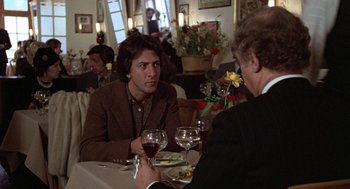 Movie still from “Kramer vs. Kramer” (1979), directed by Robert Benton – Two men are sitting at a table with wine glasses; Medium shot, Over the shoulder angle