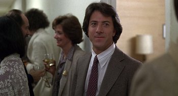 Movie still from “Kramer vs. Kramer” (1979), directed by Robert Benton – A man in a suit and tie standing next to a woman; Close Up shot, Over the shoulder angle