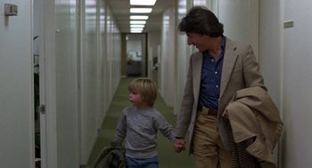 Movie still from “Kramer vs. Kramer” (1979), directed by Robert Benton – A man and a boy holding hands while walking down a hallway; Medium shot, Over the shoulder angle