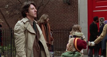 Movie still from “Kramer vs. Kramer” (1979), directed by Robert Benton – A group of people standing next to each other on a sidewalk; Medium shot, Over the shoulder angle