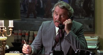 Movie still from “Kramer vs. Kramer” (1979), directed by Robert Benton – An older man talking on a phone while sitting at a desk; Close Up shot, High angle