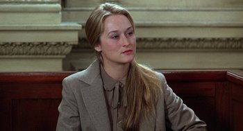 Movie still from “Kramer vs. Kramer” (1979), directed by Robert Benton – A woman sitting in a chair wearing a suit; Close Up shot, Over the shoulder angle
