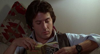 Movie still from “Kramer vs. Kramer” (1979), directed by Robert Benton – A man is reading a book while sitting on a couch; Close Up shot, Low angle
