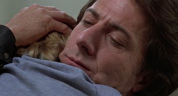 Movie still from “Kramer vs. Kramer” (1979), directed by Robert Benton – A man holding a cat while lying in a bed; Close Up shot, Low angle
