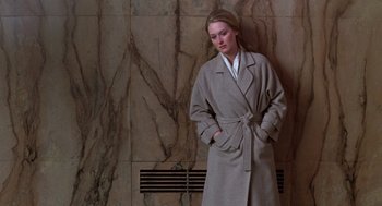 Movie still from “Kramer vs. Kramer” (1979), directed by Robert Benton – A woman in a robe standing next to a stone wall; Medium shot, High angle