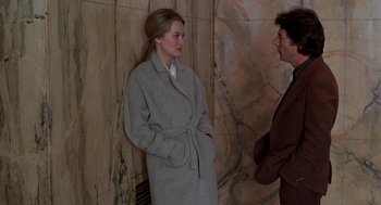 Movie still from “Kramer vs. Kramer” (1979), directed by Robert Benton – A woman in a trench coat talking to a man in a brown suit; Medium shot, Over the shoulder angle