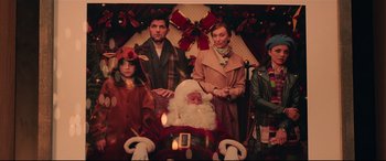 Movie still from “Krampus” (2015), directed by Michael Dougherty – A group of people posing for a picture with santa claus; Medium shot, Over the shoulder angle