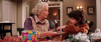 Movie still from “Krampus” (2015), directed by Michael Dougherty – An older woman holding a plate of cookies; Medium shot, Over the shoulder angle