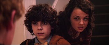 Movie still from “Krampus” (2015), directed by Michael Dougherty – A young boy and a young woman sitting next to each other; Close Up shot, Low angle