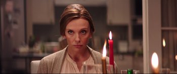 Movie still from “Krampus” (2015), directed by Michael Dougherty – A woman standing in front of a table with candles; Close Up shot, Over the shoulder angle