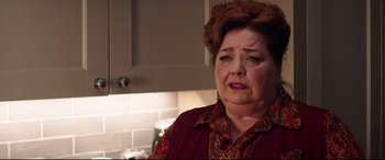 Movie still from “Krampus” (2015), directed by Michael Dougherty – An older woman in a red shirt is standing in a kitchen; Close Up shot, Over the shoulder angle