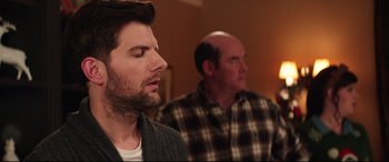 Movie still from “Krampus” (2015), directed by Michael Dougherty – A man with his eyes closed and a man with his head turned to the side; Close Up shot, Over the shoulder angle