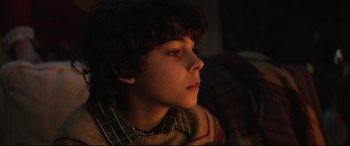 Movie still from “Krampus” (2015), directed by Michael Dougherty – A young boy is sitting in the dark looking up; Close Up shot, High angle