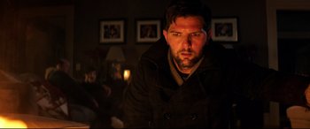 Movie still from “Krampus” (2015), directed by Michael Dougherty – A person wearing a coat in a room; Close Up shot, Over the shoulder angle