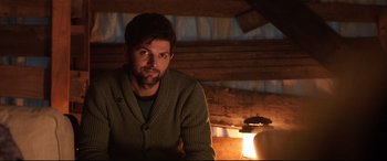Movie still from “Krampus” (2015), directed by Michael Dougherty – A man sitting in front of an open fireplace; Medium shot, Over the shoulder angle