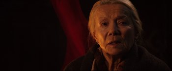 Movie still from “Krampus” (2015), directed by Michael Dougherty – An older woman with a piercing looking at the camera; Close Up shot, Over the shoulder angle