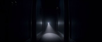 Movie still from “Krampus” (2015), directed by Michael Dougherty – A dark hallway with a light shining on it; Wide shot, High angle