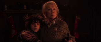 Movie still from “Krampus” (2015), directed by Michael Dougherty – An older woman and a young boy standing next to each other; Close Up shot, Low angle