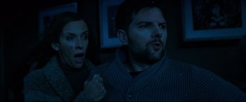 Movie still from “Krampus” (2015), directed by Michael Dougherty – A man and a woman in a dark room looking surprised; Close Up shot, Low angle