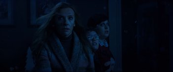 Movie still from “Krampus” (2015), directed by Michael Dougherty – A group of people standing next to each other in a dark room; Medium shot, Low angle