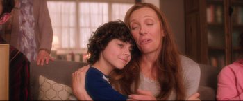 Movie still from “Krampus” (2015), directed by Michael Dougherty – A woman and a boy are hugging each other; Close Up shot, Over the shoulder angle