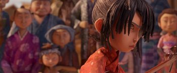 Movie still from “Kubo and the Two Strings” (2016), directed by Travis Knight – A person's face with a bunch of people behind it; Close Up shot, Over the shoulder angle
