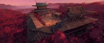 An aerial view of an asian village with a fire coming out of the roof