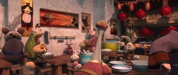Movie still from “Kung Fu Panda 2” (2011), directed by Jennifer Yuh Nelson – A group of stuffed animals sitting on top of a wooden table; Medium shot, Over the shoulder angle