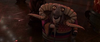 Movie still from “Kung Fu Panda 2” (2011), directed by Jennifer Yuh Nelson – A stuffed ram sitting on top of a wooden table; Medium shot, Over the shoulder angle
