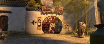 Movie still from “Kung Fu Panda 2” (2011), directed by Jennifer Yuh Nelson – An animated scene of an oriental building with a person sitting in the doorway; Extreme Wide shot, High angle