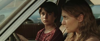 Movie still from “Labor Day” (2013), directed by Jason Reitman – A boy and a woman sitting in the back of a car; Close Up shot, Over the shoulder angle