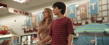 Movie still from “Labor Day” (2013), directed by Jason Reitman – A woman standing next to a young boy in a store; Medium shot, Low angle