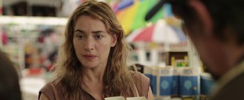 Movie still from “Labor Day” (2013), directed by Jason Reitman – A person holding a book; Close Up shot, Over the shoulder angle