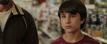Movie still from “Labor Day” (2013), directed by Jason Reitman – A young boy with green eyes stares into the camera; Close Up shot, Over the shoulder angle