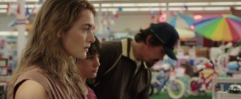 Movie still from “Labor Day” (2013), directed by Jason Reitman – A man and a woman standing next to each other in a store; Close Up shot, Over the shoulder angle
