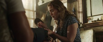 Movie still from “Labor Day” (2013), directed by Jason Reitman – A woman in a blue shirt is cutting something with a knife; Medium shot, Over the shoulder angle