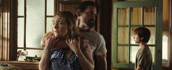 Movie still from “Labor Day” (2013), directed by Jason Reitman – A man and a woman standing next to each other in front of a window; Medium shot, Over the shoulder angle