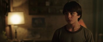 Movie still from “Labor Day” (2013), directed by Jason Reitman – A young boy standing in a dark room; Close Up shot, Low angle