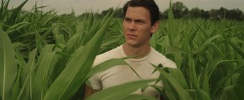 Movie still from “Labor Day” (2013), directed by Jason Reitman – A man standing in a field of green plants; Close Up shot, Low angle