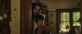 Movie still from “Labor Day” (2013), directed by Jason Reitman – A man and a boy standing next to each other in a kitchen; Close Up shot, Low angle