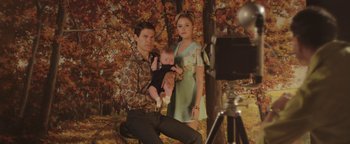 Movie still from “Labor Day” (2013), directed by Jason Reitman – A man and a woman holding a baby in front of a camera; Medium shot, High angle