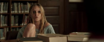 Movie still from “Labor Day” (2013), directed by Jason Reitman – A woman sitting in front of a stack of books; Medium shot, High angle