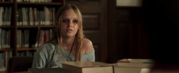 Movie still from “Labor Day” (2013), directed by Jason Reitman – A woman sitting in front of a stack of books; Close Up shot, Over the shoulder angle