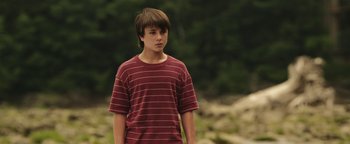 Movie still from “Labor Day” (2013), directed by Jason Reitman – A young man in a red striped shirt looks to his left; Medium shot, Low angle