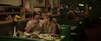 Movie still from “Labor Day” (2013), directed by Jason Reitman – A man and a woman sitting at a table with plates of food on it; Medium shot, Over the shoulder angle
